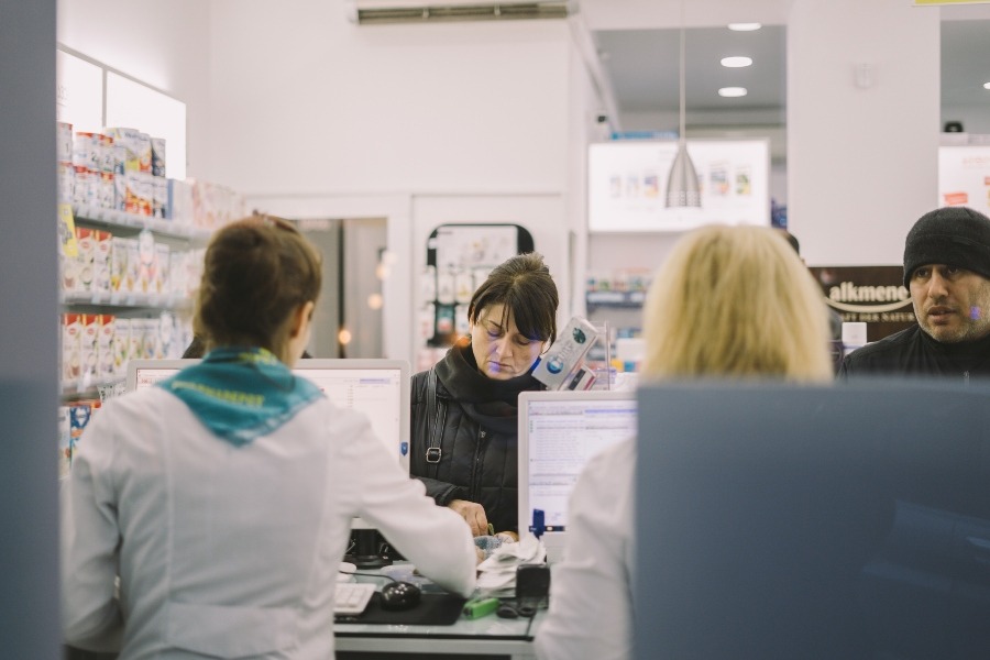 pharmacy counter with woman being served by staff